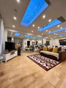 ein Wohnzimmer mit einem Sofa und einem TV in der Unterkunft Sunny London Garden Apartment in London