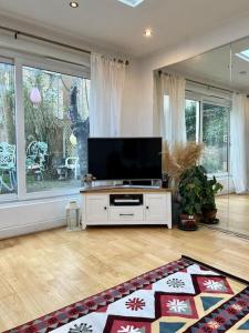 uma sala de estar com uma televisão de ecrã plano sobre uma mesa em Sunny London Garden Apartment em Londres