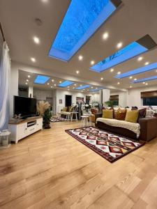 a large living room with a couch and a tv at Sunny London Garden Apartment in London