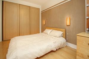 um quarto com uma grande cama branca e 2 almofadas em Stylish Merchant City Apartment em Glasgow