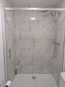 a bathroom with a shower with white marble tiles at 1 Bedroom Flat Available in Oldham