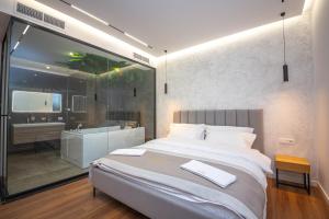 a bedroom with a large bed and a bathroom at Hotel Riviera in Tirana