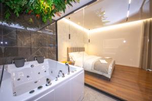 a bathroom with a tub and a bed in a room at Hotel Riviera in Tirana