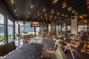 un ristorante con tavoli, sedie e finestre di Hotel Riviera a Tirana