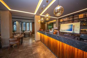 a bar in a restaurant with a computer on the counter at Hotel Riviera in Tirana