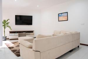 a white living room with a couch and a tv at 5 bdr house near Praça Center, AC & Wifi - LCGR in Praia
