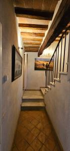 a hallway with stairs and a painting on the wall at Casale Esclusivo con Piscina e Vista su San Gimignano in San Gimignano