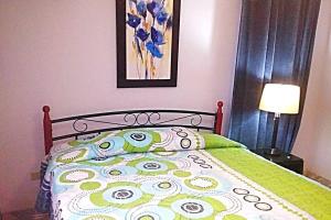 a bed with a green comforter with eyes on it at Casa Piscina - House with a pool in David in David