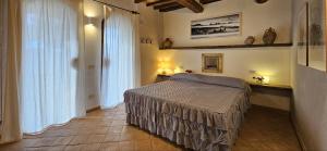 a bedroom with a bed in a room with windows at Casale Esclusivo con Piscina e Vista su San Gimignano in San Gimignano +19 photos