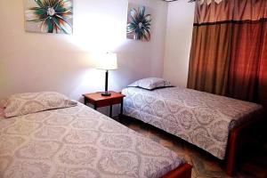 a bedroom with two beds and a lamp and a window at Casa Piscina - House with a pool in David in David