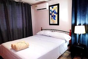 a bedroom with a white bed with a bag on it at Casa Piscina - House with a pool in David in David