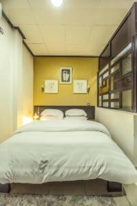 - une chambre avec un grand lit et un mur jaune dans l'établissement VDR Hotel, à Douala