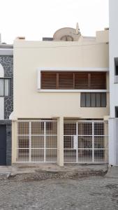 - une vue extérieure sur un bâtiment blanc avec des garages dans l'établissement 5 bdr house near Praça Center, AC & Wifi - LCGR, à Praia