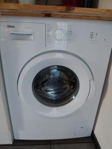 a white washing machine with a black door at Gites Les Granges De Flolie in Beauteville