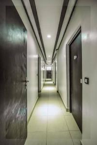 a hallway with two doors and a hallway with white tiles at VDR Hotel in Douala