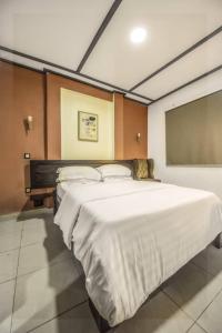 een slaapkamer met een groot wit bed in een kamer bij VDR Hotel in Douala