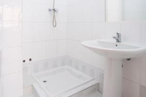 a white bathroom with a sink and a shower at 5 bdr house near Praça Center, AC & Wifi - LCGR in Praia
