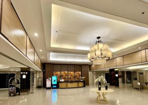 a lobby with a chandelier and a table in a building at Shell Residences by Amonbrey Suite nr airport in Manila