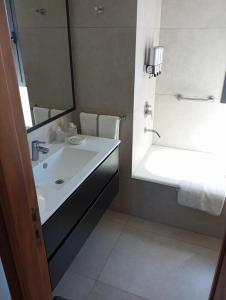 ein Badezimmer mit einem weißen Waschbecken und einer Dusche in der Unterkunft Terrazas Club Hotel in Villa Gesell