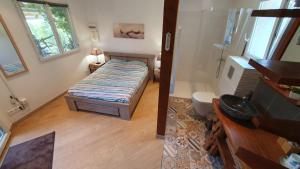 a small bedroom with a bed and a bathroom at A VIGNA VECCHIA chambre d'hôtes in Porto-Vecchio