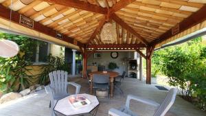 a patio with a wooden roof with a table and chairs at A VIGNA VECCHIA chambre d'hôtes in Porto-Vecchio