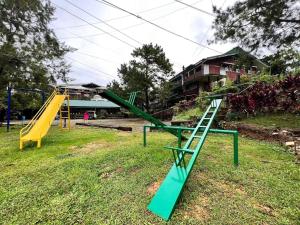 a playground with two swings and a slide at Classic, Cozy House for Transient in Baguio City 1 in Baguio