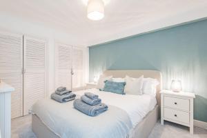 a bedroom with a white bed with towels on it at The Hideout in Sandgate