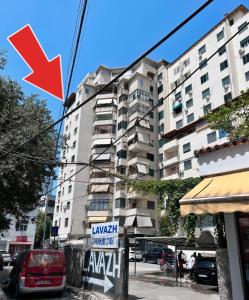 una freccia rossa che punta verso un edificio alto di Cozy Central Apartment a Tirana