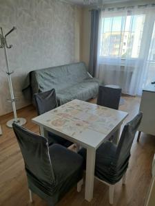 uma sala de estar com uma mesa e cadeiras e um sofá em Słoneczny - Mala Apartamenty em Wejherowo