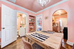 a dining room with pink walls and a wooden table at Strawberry Lodge - City card 4 local business in Oklahoma City
