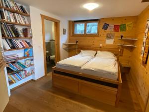 um quarto com uma cama e uma estante de livros em La Clé des Champs em Hérémence