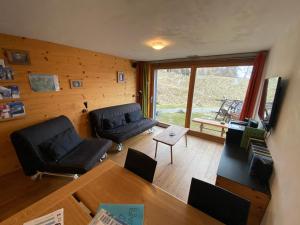 a living room with two couches and a table at La Clé des Champs in Hérémence