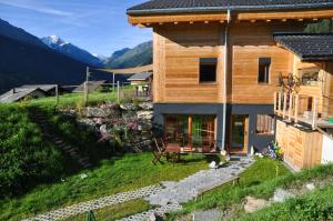 ein Haus auf einem Hügel mit Bergen im Hintergrund in der Unterkunft La Clé des Champs in Hérémence