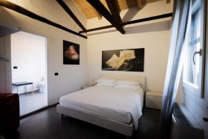 1 dormitorio con cama blanca y ventana en LA CASCINA DEL BALSAMICO, en Gaggio