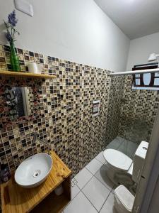 y baño con aseo, lavabo y ducha. en Tamboleiros Hotel & Hostel, en Salvador