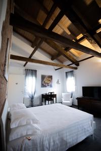 a bedroom with a large white bed and a chair at LA CASCINA DEL BALSAMICO in Gaggio