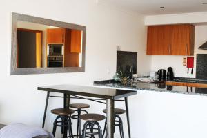 a kitchen with two bar stools and a mirror at Apartment with terrace Albufeira Olhos de Água in Albufeira
