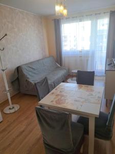 a living room with a table and a couch at Słoneczny - Mala Apartamenty in Wejherowo