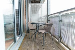 un balcón con 2 sillas y una mesa. en China Town 2 Bedroom Apartment - Balcony - Secure Parking 48A en Birmingham