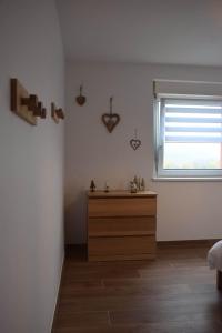 a bedroom with a wooden dresser and a window at La Perle d'Alsace in Bernardswiller