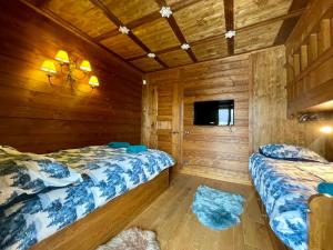 a bedroom with two beds and a tv in a cabin at Mon Bijou in Sauze d'Oulx