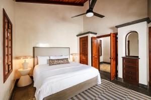 a bedroom with a bed and a ceiling fan at Casa Libelula in Tamarindo