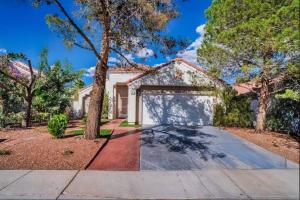 a house with a garage and a tree at Pet Friendly Rancher with Pool/SW Las Vegas in Las Vegas