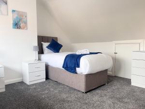 a bedroom with a large bed with blue and white sheets at Wembley Stadium Central Modern & Cozy Apartment in London
