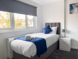 a bedroom with a bed with two towels on it at Wembley Stadium Central Modern & Cozy Apartment in London