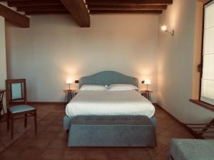 sypialnia z dużym łóżkiem i krzesłem w obiekcie Agriturismo San Giuseppe w mieście Gattatico