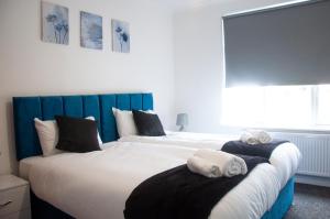 a bedroom with two beds with towels on them at Wembley Stadium Central Modern & Cozy Apartment in London