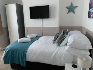 ein Schlafzimmer mit einem Bett mit Kissen und einem TV in der Unterkunft Coronation Place, Durham in Durham