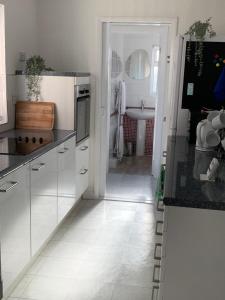 a kitchen with white cabinets and a white tile floor at Coronation Place, Durham in Durham