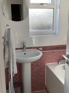 La salle de bains est pourvue d'un lavabo blanc et d'une fenêtre. dans l'établissement Coronation Place, Durham, à Durham